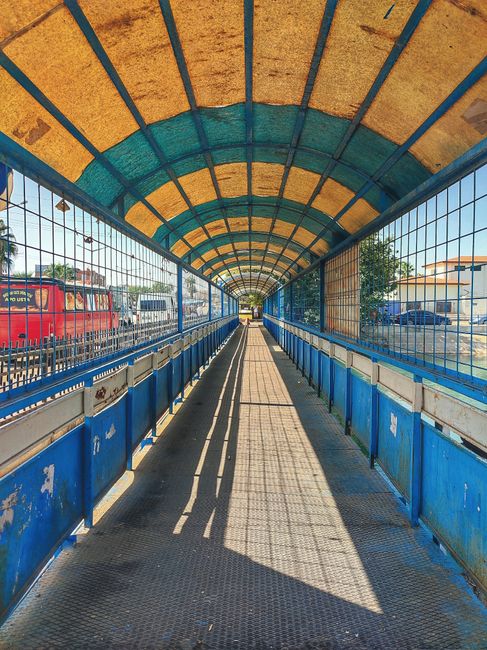 A large, weathered railway bridge spans over a busy street intersection in Camden, with the words '20 FOOT' painted above the word 'CAMDEN LOCK' on the side of the bridge in bold yellow letters. The b